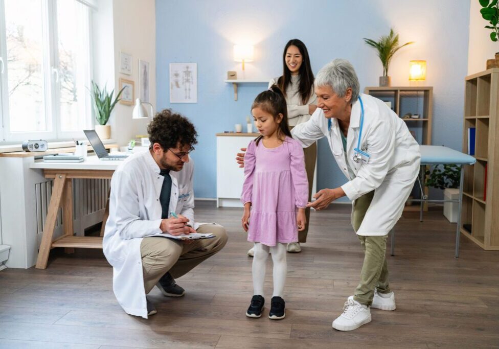 Child with doctors during medical checkup.